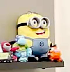 Animatronic plush minion on a living room shelf.