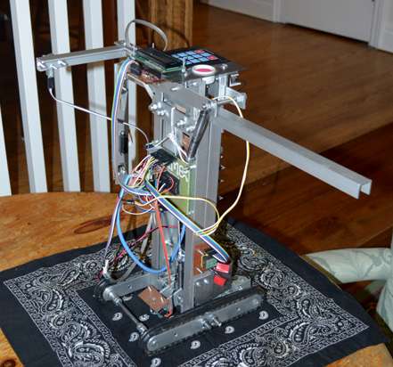 Inukshuk robot made out of aluminum, featuring metal treads and a motorized arm